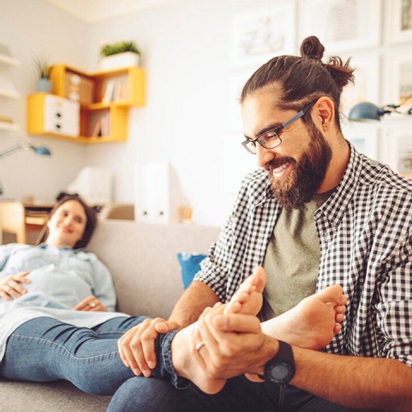 man massaging a woman's feet