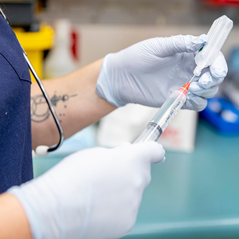 gloved hands and needle