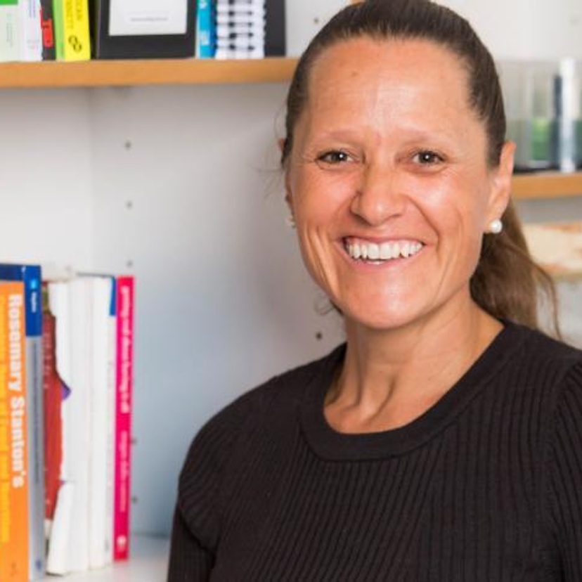 Woman smiling in front of a bookcase