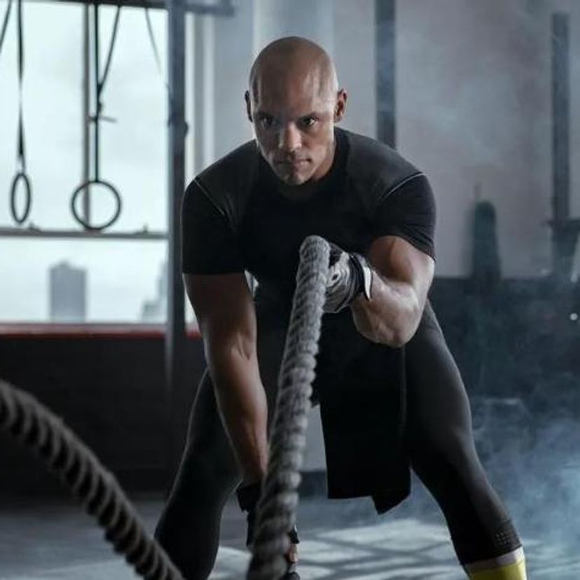 Man swinging ropes in the gym