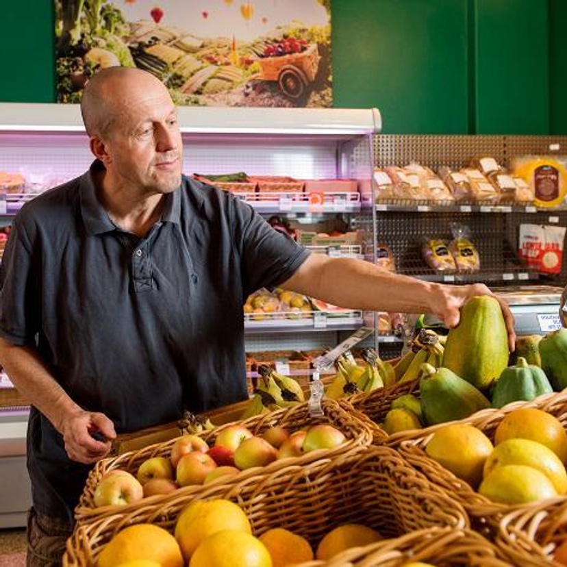 A man inspecting fruit at a supermarket