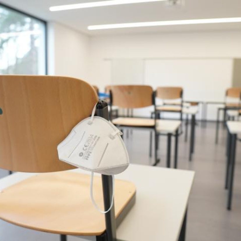 Empty classroom with facemask slung over a chair