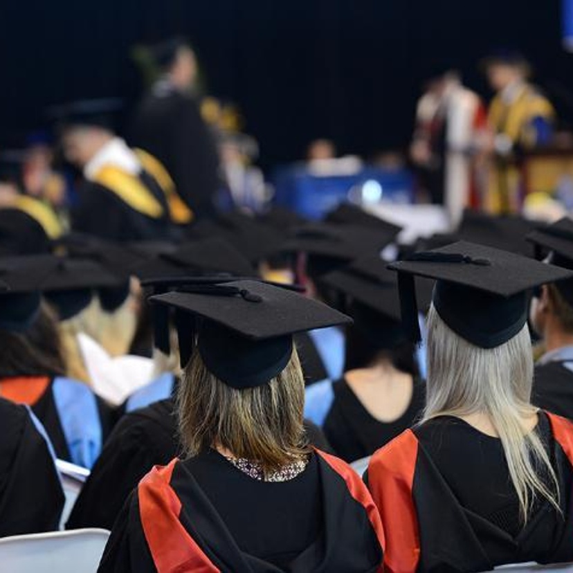 Students at a graduation ceremony wearing ceremonial gowns and motar boards