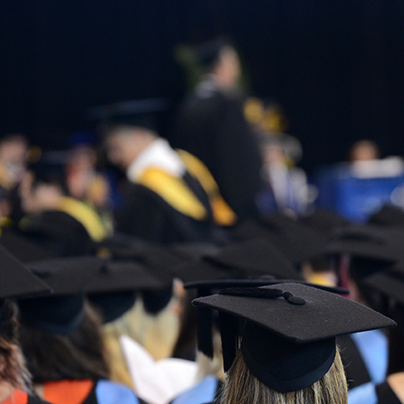 Students at a graduation ceremony wearing ceremonial gowns and motar boards