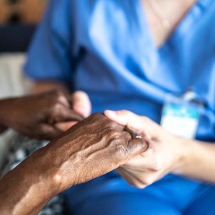 Healthcare working holding person's hand
