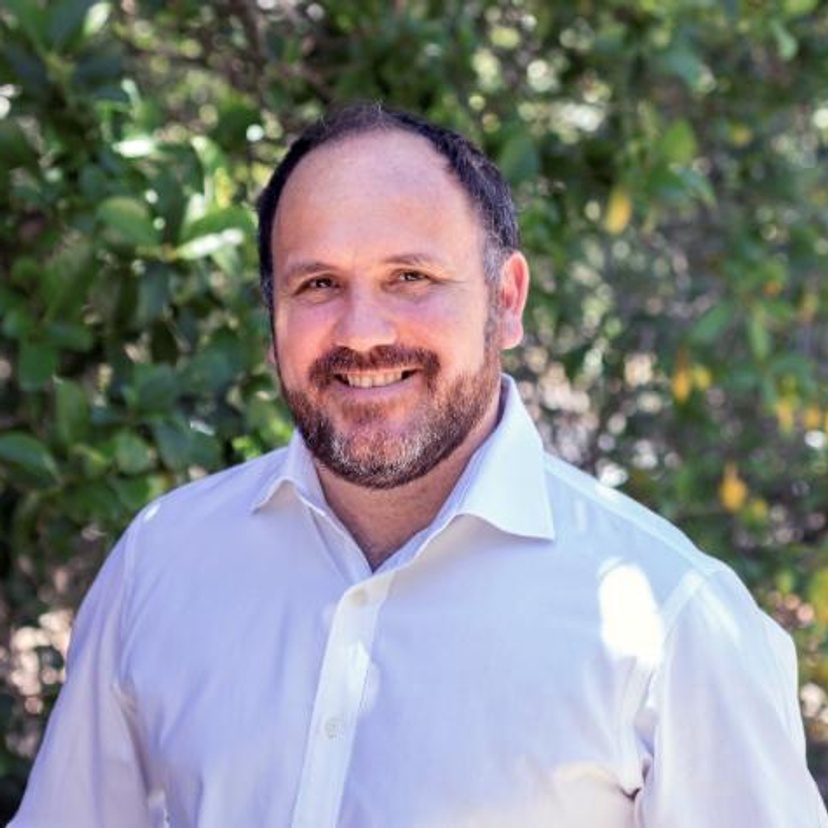 A man with a beard wearing a white shirt