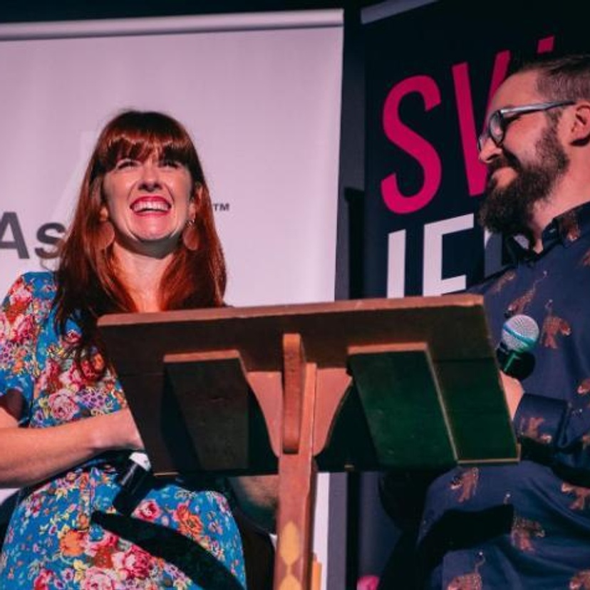 Woman and man smiling at lecturn