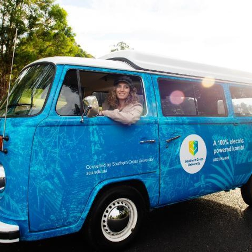 Kombi van in Southern Cross University colours with two people inside