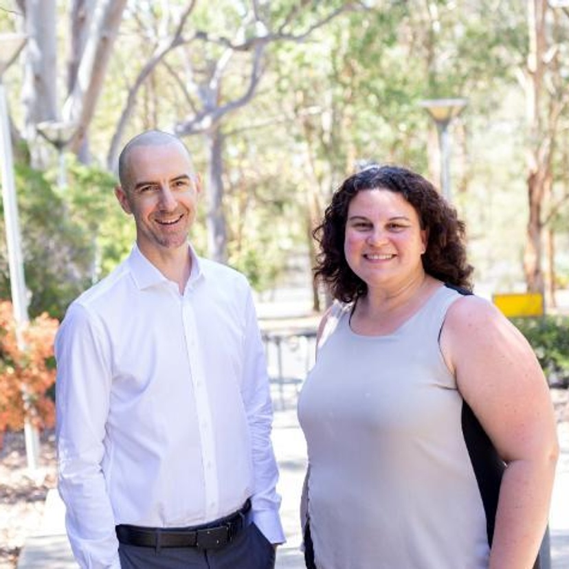 A man and woman standing in front of gum trees