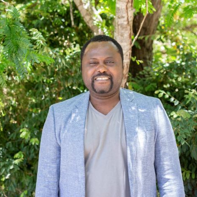 Man in business jacket in front of trees