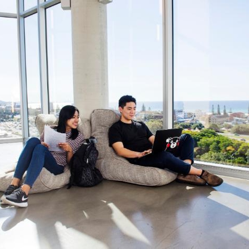 Two students with laptops at the Gold Coast campus