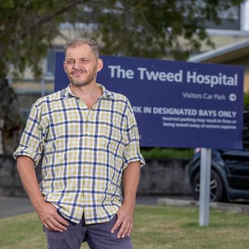 A man standing in front of a sign