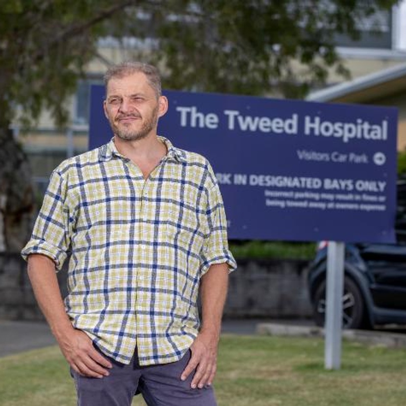 A man standing in front of a sign