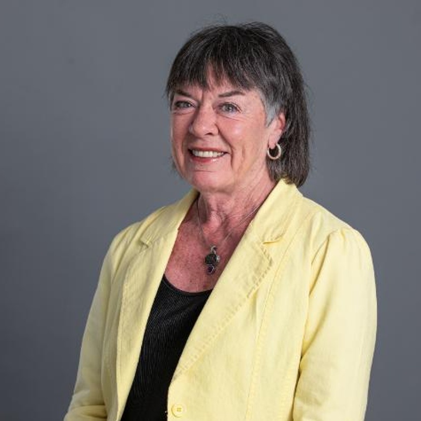 A woman wearing a yellow jacket and black top