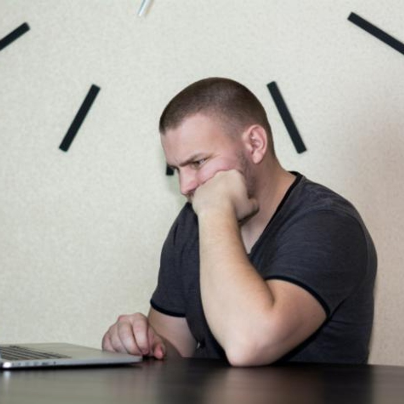 Man looking upset in front of a laptop