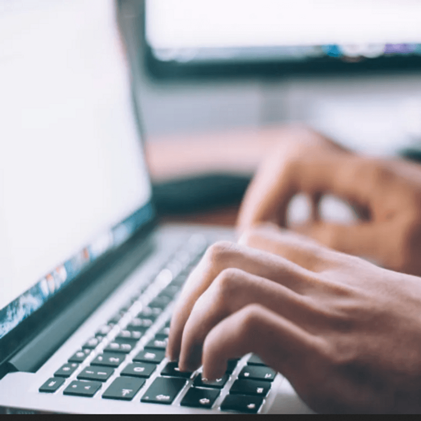 Person's hands using keyboard of a laptop