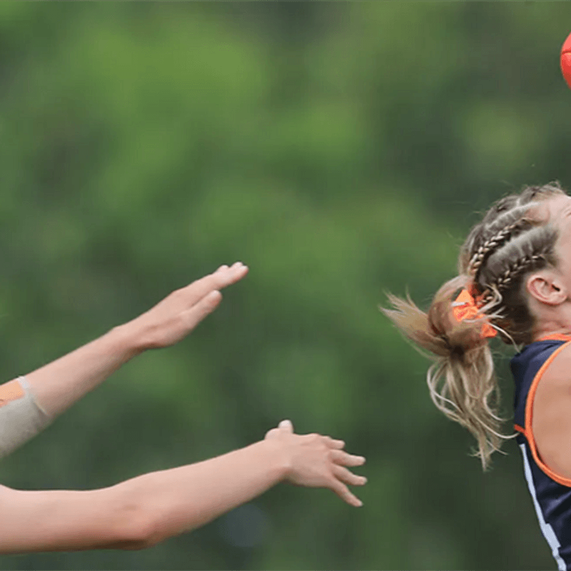 Two women playing AFL taking a mark