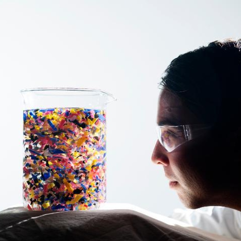 Engineering student looking at plastics in beaker