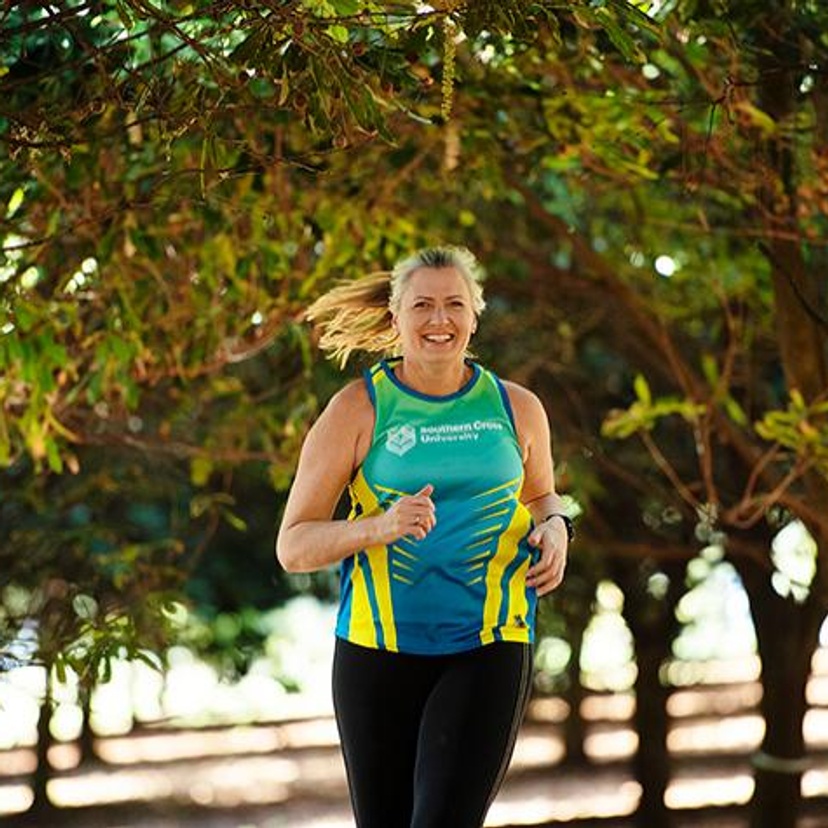 Kirsten Ellis running through macadamia orchard