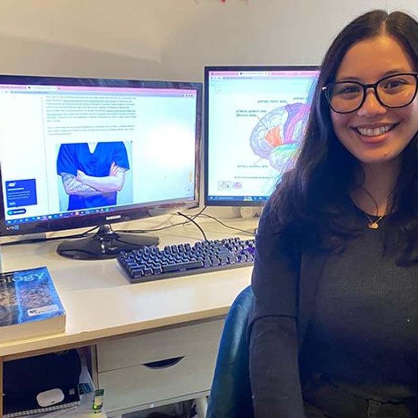 A woman sitting in front of her computer and textbooks