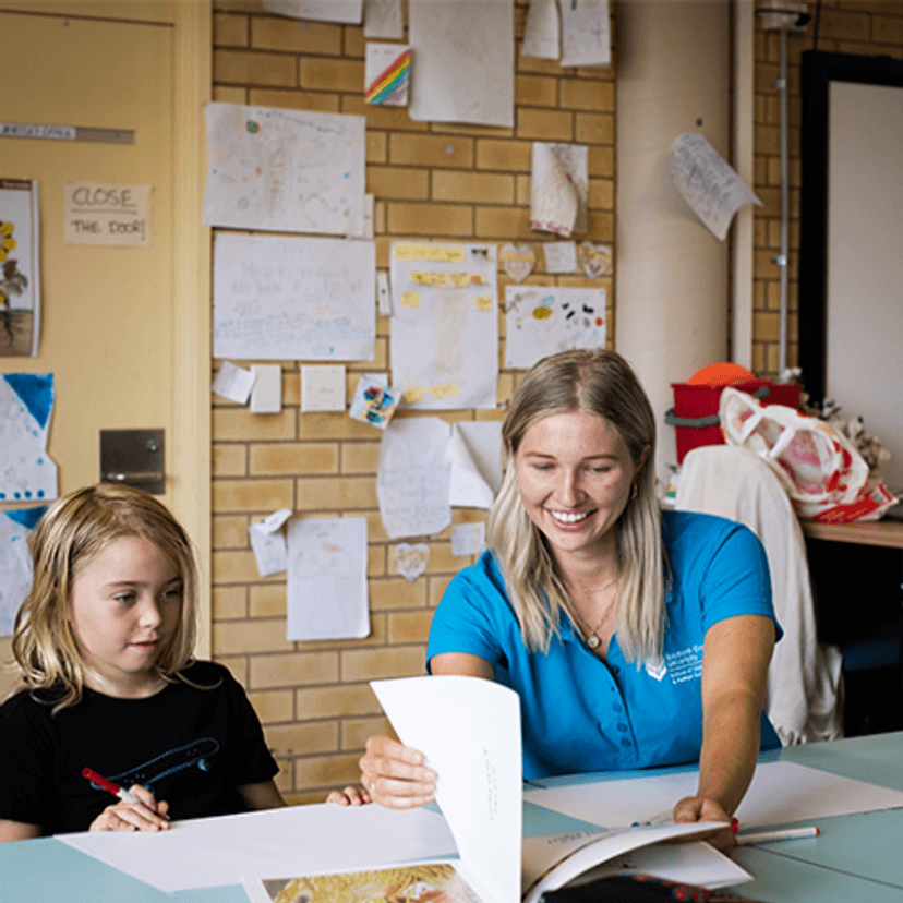 Student from The Living School with occupational therapy student in classroom looking at book