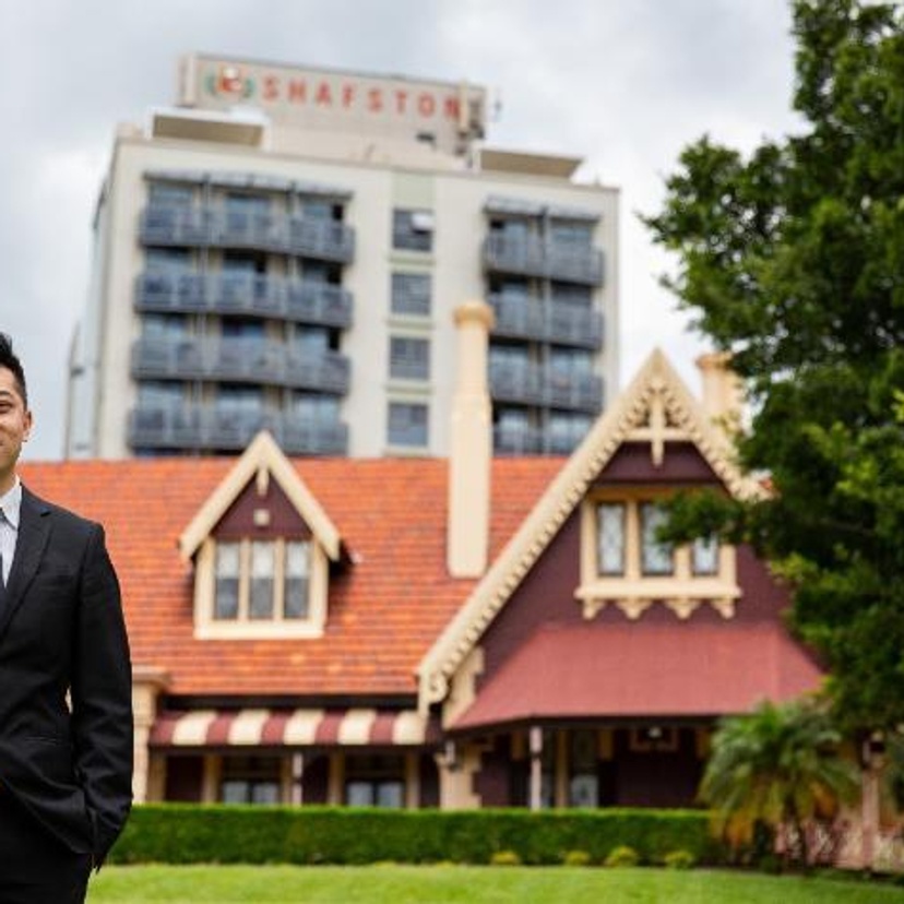 A man stands in front of a historic building