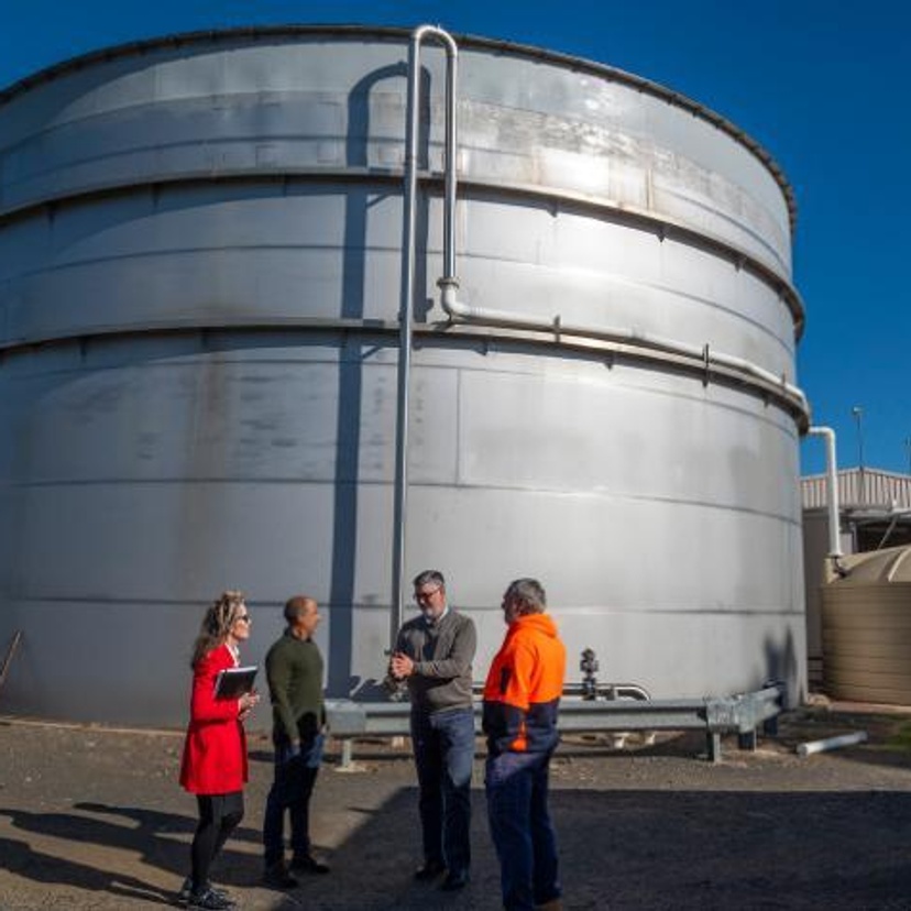 A group of people in front of a large silo