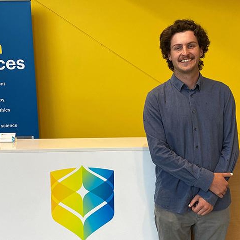 A man standing next to SCU health signage