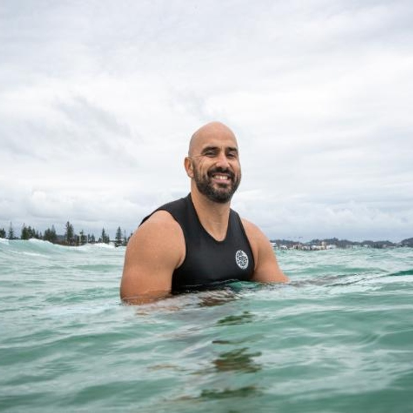 Man on a surfboard smiling at the camera