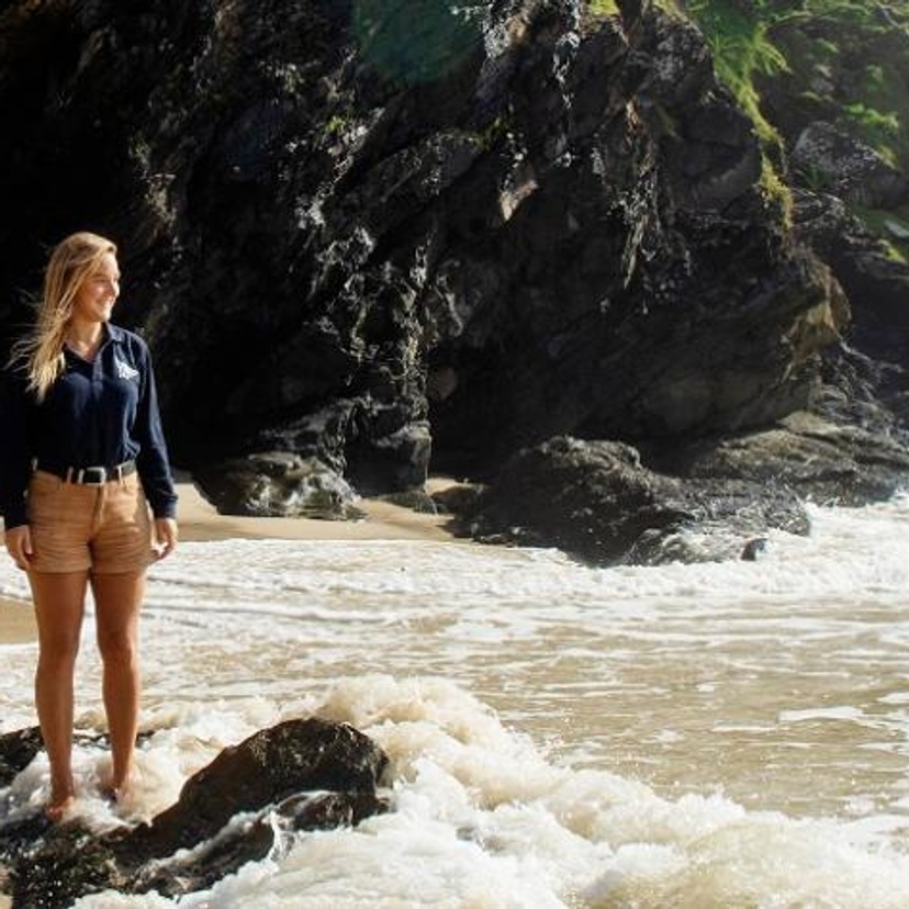 Girl standing in ocean looking out to sea