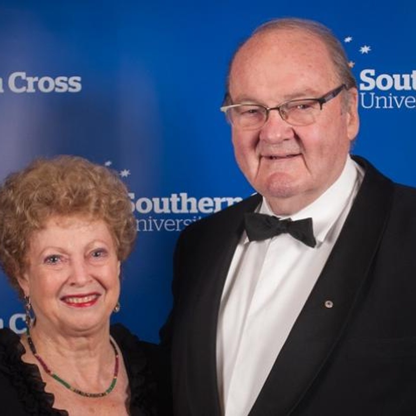 A woman and a man standing against a blue background