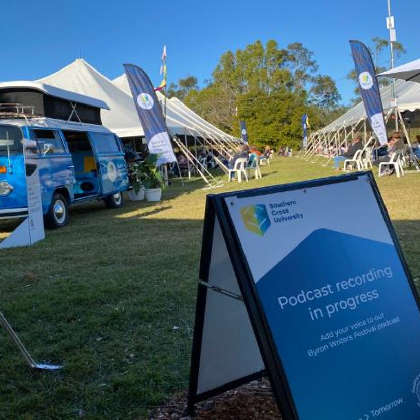 A kombi parked next to a large white marquee with a sign in the foreground