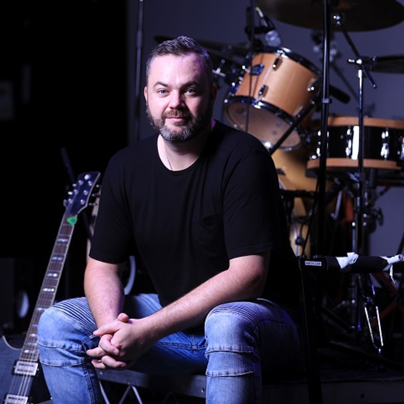Man sitting in front of a drum kit