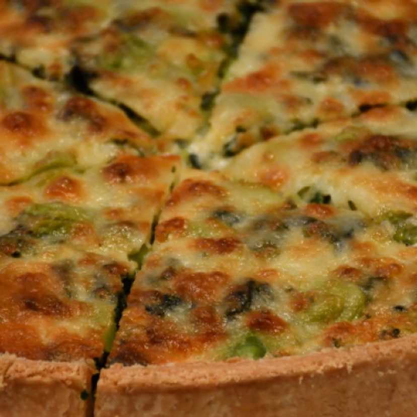 A quiche sliced and served on a plate.