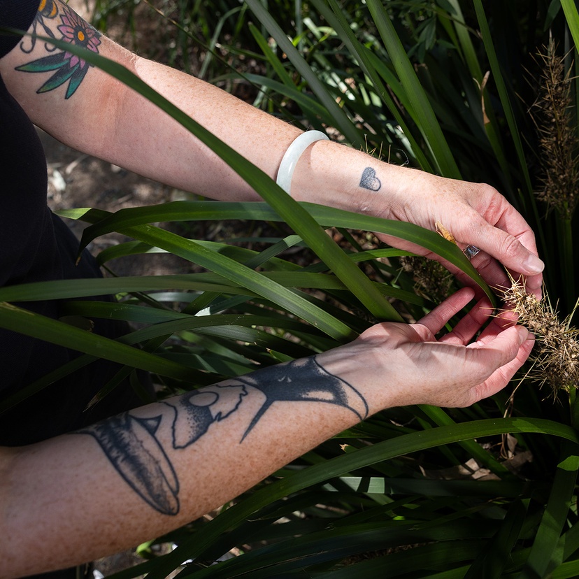 Woman holding leafy plant in arms