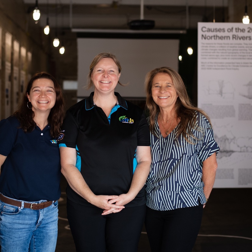 three women standing in an urban exhibition space