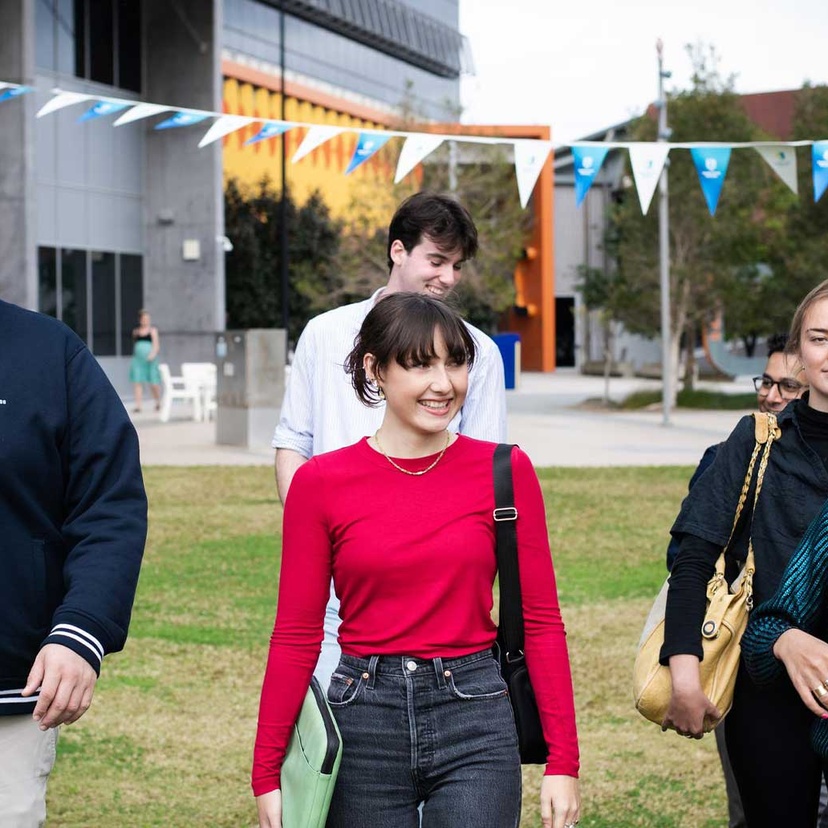 Students walking in grassy field at Gold Coast campus