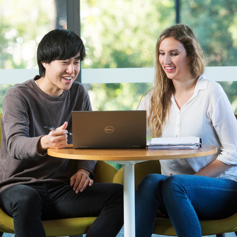 Male and female looking at open laptop
