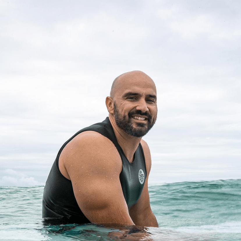 Man sitting on surfboard in ocean