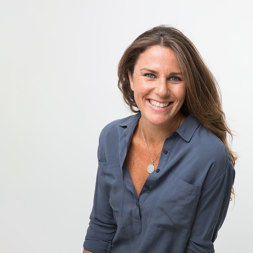 Headshot of woman smiling with blue long sleeve shirt and necklace