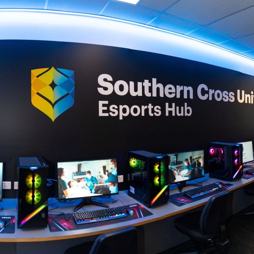 Computers with southern cross branding on black wall above