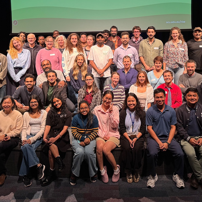 Large group of people smiling on a stage