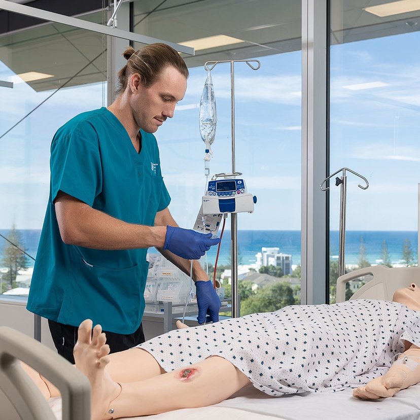 Student working on nursing sim doll