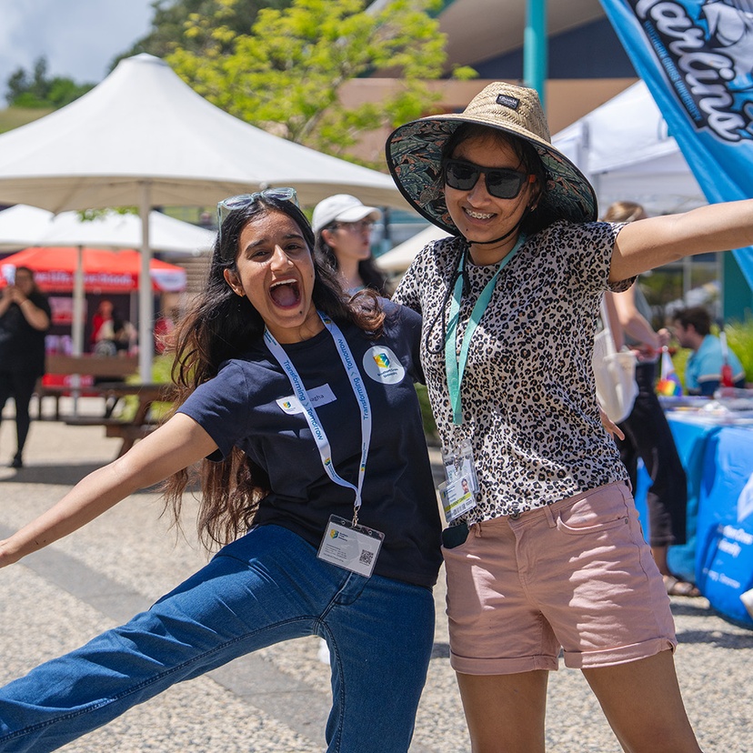 Two people hugging excitedly and smiling at camera