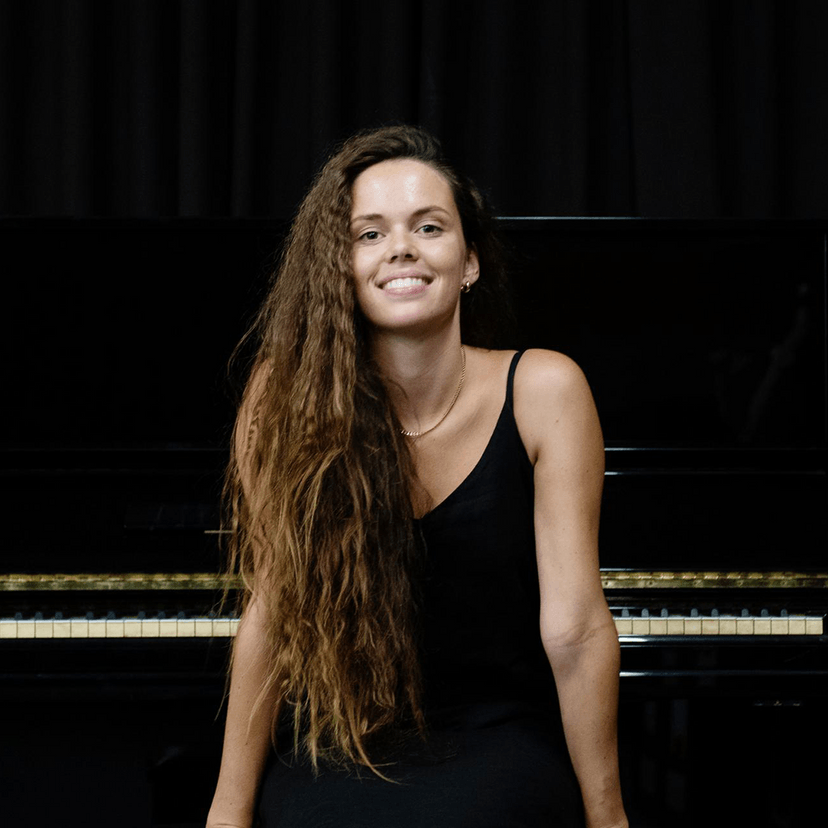 Kaliya smiling while sitting at piano