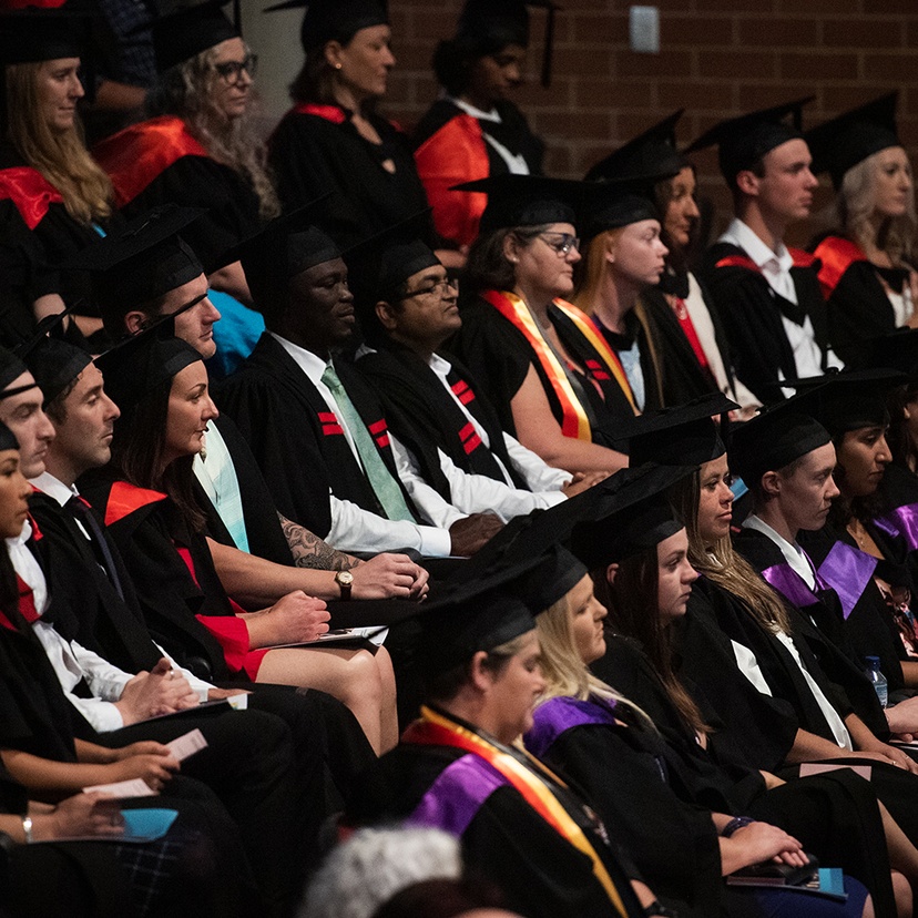 A group of students in ceremonial caps and gowns