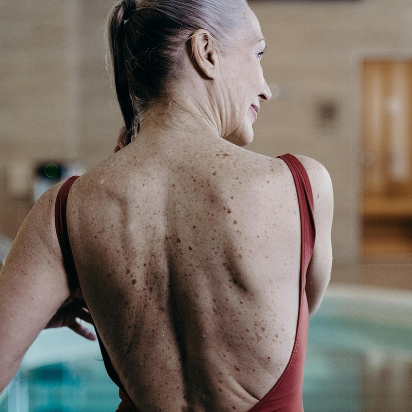 Back view of an elderly woman in maroon swimwear