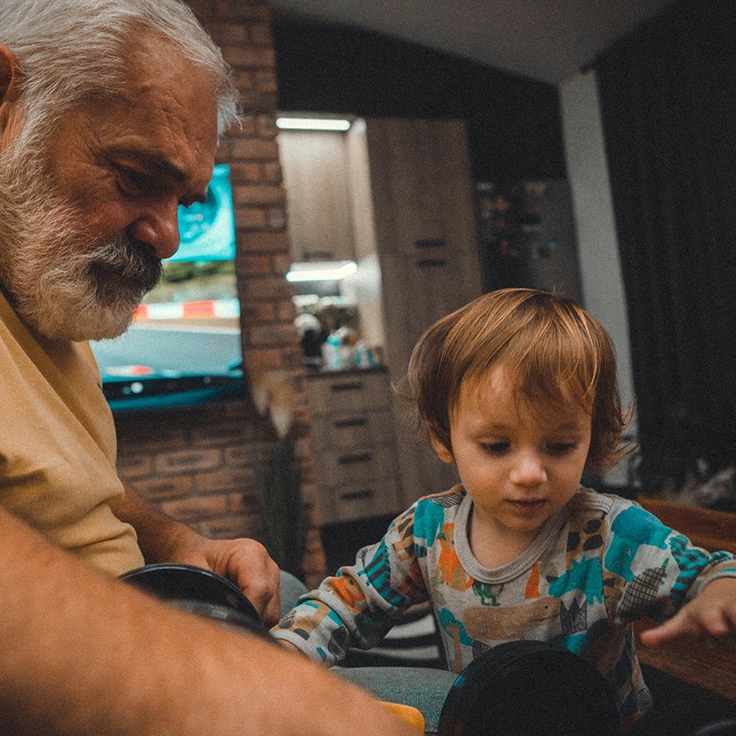Grandfather with a grey beard minding a grandchild