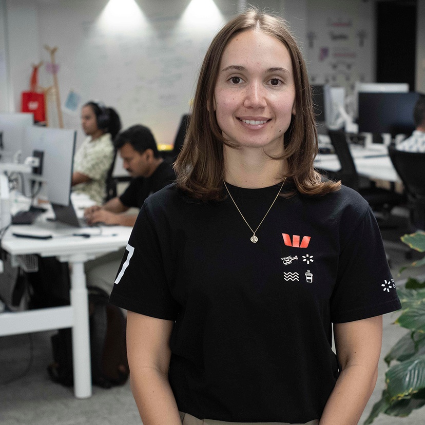 A woman in front of a group of people working on computers