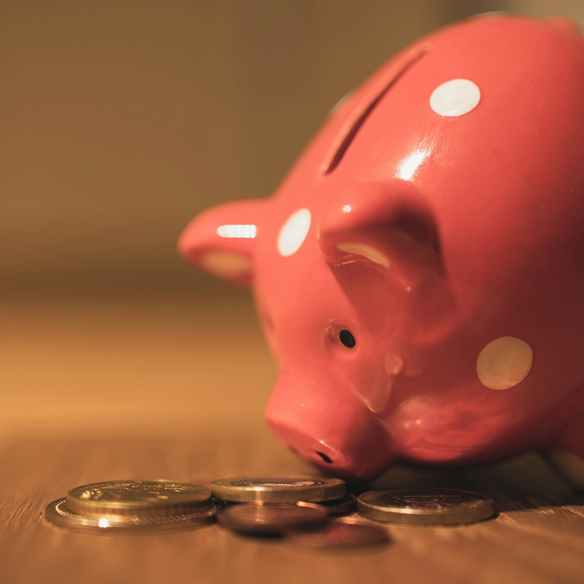 pink pig coin bank on brown wooden table eating coins